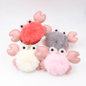 Plush crab pom-pom keychains in assorted coastal colors