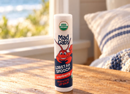 Organic Lobstah Smooch Lip Balm in a styled wooden cottage table setting, with Seasonal Maine logo.