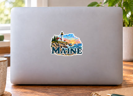 Maine Lighthouse and Sailboat Sunset Vinyl Sticker – 3 Inch shown on a laptop in a styled setting, with Seasonal Maine logo. Includes sticker only.
