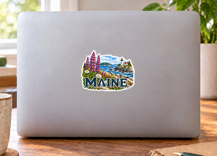 Maine Lupines and Lighthouse Vinyl Sticker – 3 Inch shown on a laptop in a styled setting, with Seasonal Maine logo. Includes sticker only.