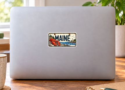 Maine Lobster Vintage License Plate Vinyl Sticker – 3 Inch shown on a laptop in a styled setting, with Seasonal Maine logo. Includes sticker only.