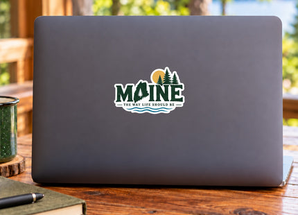 Maine State & Pines — The Way Life Should Be Vinyl Sticker – 3 Inch shown on a laptop in a styled setting, with Seasonal Maine logo. Includes sticker only.