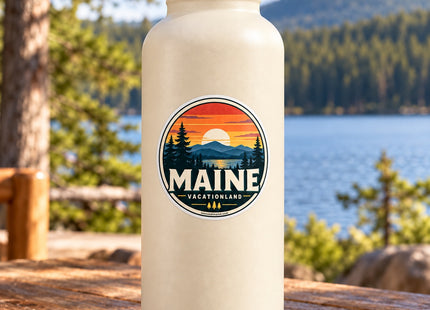 Maine Sunset Vacationland Badge Vinyl Sticker – 3 Inch shown on a water bottle in a styled setting, with Seasonal Maine logo. Includes sticker only.