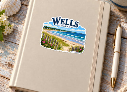 Wells Maine Beach Vinyl Sticker – 3 Inch shown on a notebook in a styled setting, with Seasonal Maine logo. Includes sticker only.